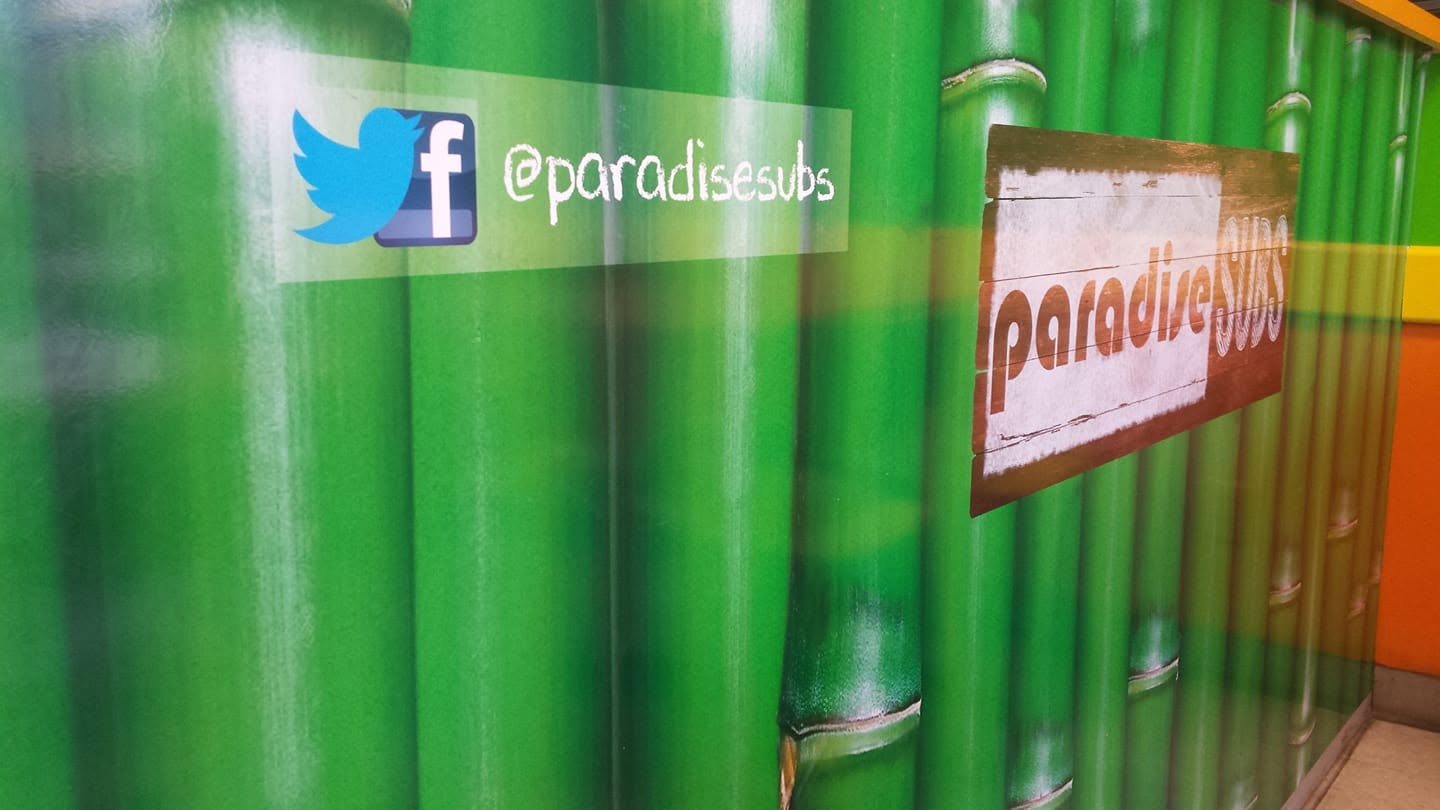 Bamboo-patterned accent wall with the Paradise Subs sign